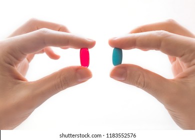 Female hands hold blue and red tablets. Close-up isolated on white background. Right choice concept
