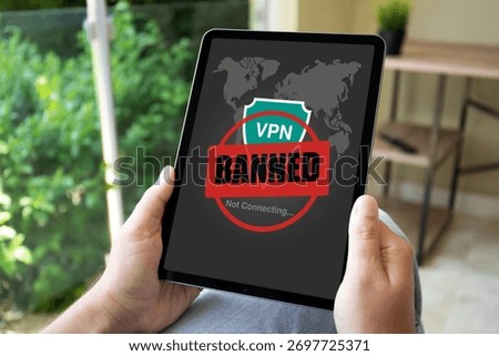 female hands hold computer tablet with VPN banned of screen on green office background