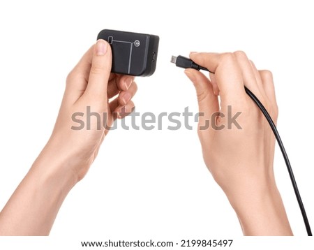Female hands hold a debugger flasher with a usb port for program chips and memory and insert a usb cable with a connector. Isolated on white background.