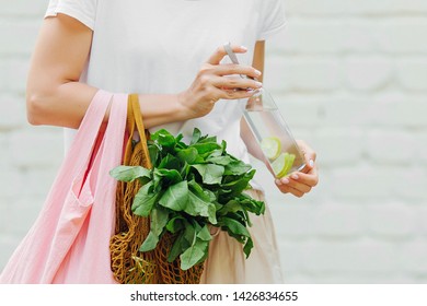 Female hands hold eco bag of vegetables, greens and reusable water bottle. Zero waste. Sustainable lifestyle concept. - Shutterstock ID 1426834655