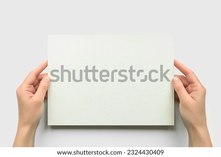 female hands hold empty rectangular cardboard banner on white background. empty space for text