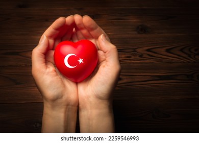 female hands hold and giving red heart in the form of a Turkey flag, support concept.