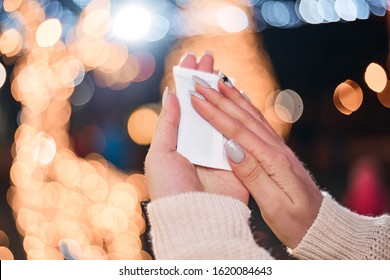 Female hands hold hand warmers on night lights background. - Shutterstock ID 1620084643