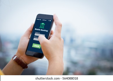 Female hands hold mobile banking on smart phone on blurred urban city as background - Shutterstock ID 564088018