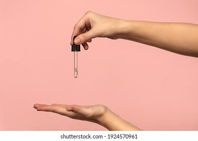 Female hands hold a pipette filled with natural oil. Cosmetology. - Shutterstock ID 1924570961