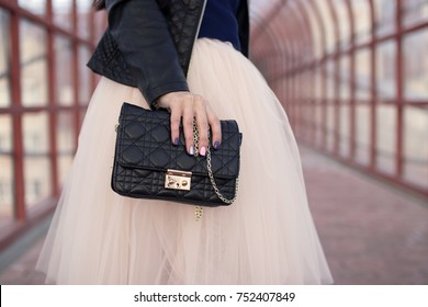 Female Hands Holding Black Handbag Clutch Amid The Skirt-tutu Pink