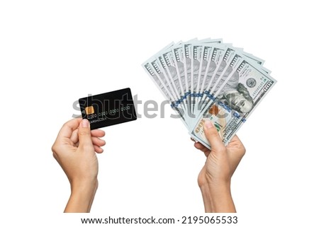 Female hands holding a black plastic credit card and a stack of hundred-dollar cash bills isolated on a white background. Shopping, payment for purchases, banking operations. Money, finance