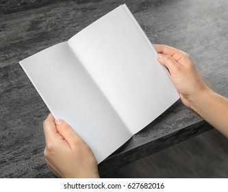 Female Hands Holding Blank Brochure At Table