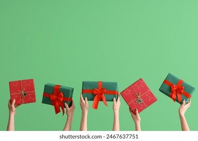 Female hands holding Christmas gift boxes on green background - Powered by Shutterstock