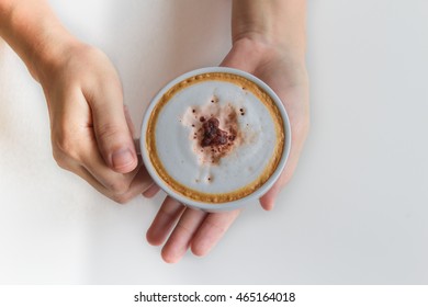 Female hands holding cup of coffee on white background