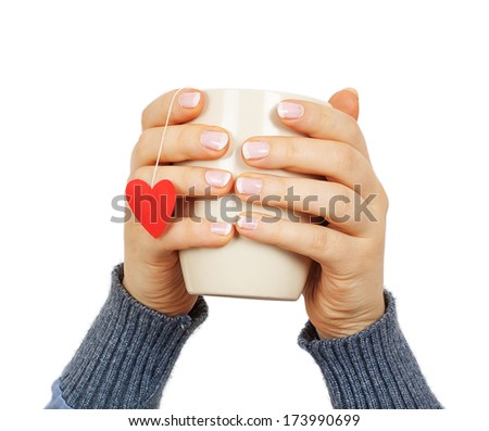 female hands holding a cup with paper  heart isolated on white background