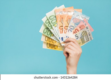 Female hands holding euro banknotes on a blue background. Euro Money. euro cash background