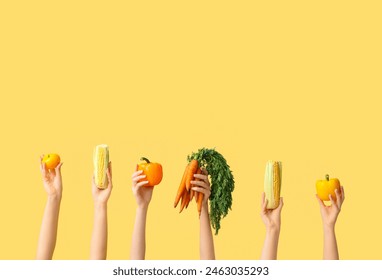 Female hands holding fresh vegetables on yellow background - Powered by Shutterstock