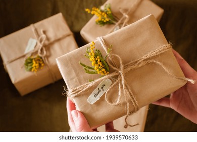 female hands holding gift boxes decorated with yellow flowers a thank you. Appreciate Concept. top view. High quality photo