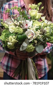 female hands holding green bouquet of Bronica, Brassica, Orchid, eustoma, hydrangea