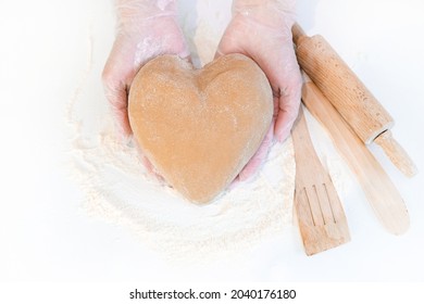 female hands holding heart shaped dough top view. Baking ingredients on white table - Powered by Shutterstock