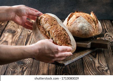 Female hands holding homemade sourdough bread on rustic background. - Powered by Shutterstock