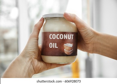 Female Hands Holding Jar With Coconut Oil On Blurred Background