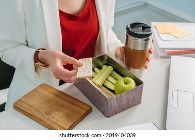 Female hands holding lunch zero waste box, food delivery box with healthy meal weight loss diet menu, vegan food at workplace in office. Office employee having vegan lunch at workplace.