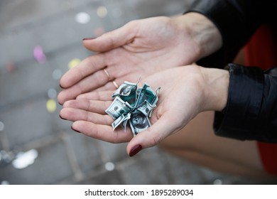 Female hands are holding  miniature US dollar bills depicting the shrinking of dollar