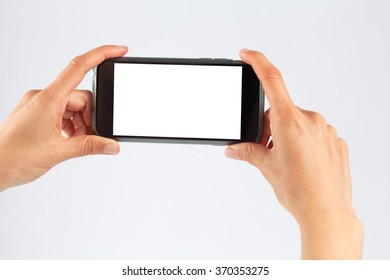 Female Hands Holding Mobile Phone In Horizontal Orientation. Isolated On White With White Screen.