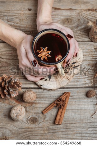 female hands holding a mug of festive mulled wine