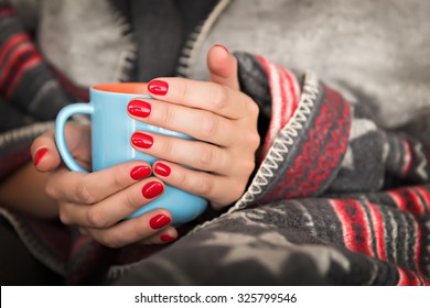 female hands holding a mug of hot beverage
