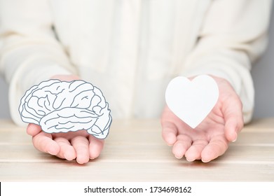 Female hands holding paper cut brain and soul. Conflict between emotions and rational thinking. Balance and equilibrium between mind and heart concept - Shutterstock ID 1734698162