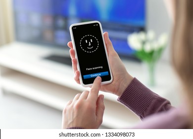 Female Hands Holding Phone With Face ID Scanning On The Screen In Room Home