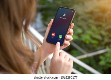 Female Hands Holding Phone With Incoming Call On The Screen On The Street In The Park