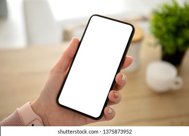 female hands holding phone with isolated screen in the house in room