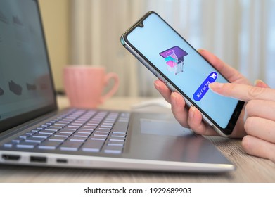 Female hands holding a phone and making a purchase online. Online shopping concept. Woman using a smartphone for online shopping.