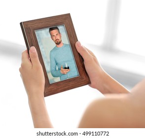 Female Hands Holding Photo Frame With Picture Of Man. Happy Memories Concept.