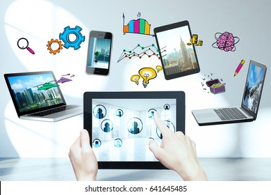 Female Hands Holding And Pointing At Tablet With Multiple Devices And Drawings Above. Cloud Computing Concept