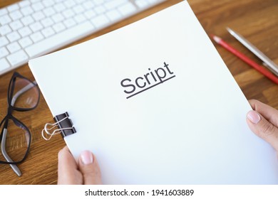 Female hands holding script over table closeup