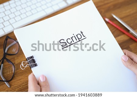 Female hands holding script over table closeup