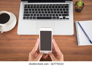 female hands holding smartphone on the table in the office - Shutterstock ID 267776513