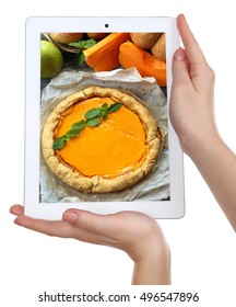 Female hands holding tablet on white background. Photo of food on tablet screen.