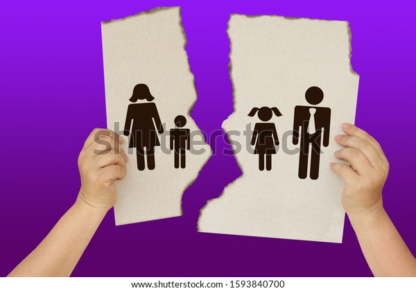 female hands holding a torn poster\
separating the symbol of a man and a woman with children, the\
concept of a breakup, divorce, separation, family\
tragedy