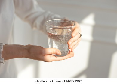 Female hands holding a transparent glass of water. Healthy lifestyle. - Shutterstock ID 1349893202