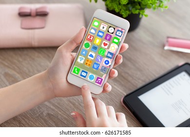 female hands holding white phone with home screen icons apps and e-rider 