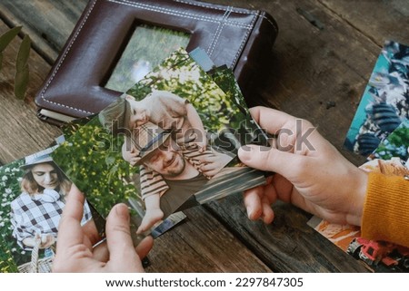Female hands holds printed photo for family photo album. 