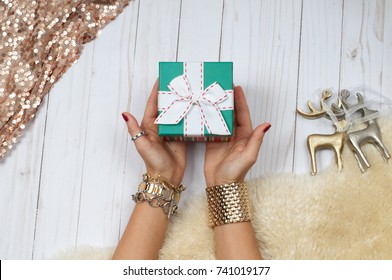 Female hands with jewelry and gift. Fashion accessories, wrist watches, glamor bracelets and rings