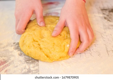 Female hands knead the dough for a sweet cake on a table sprinkled with flour. Making shortcrust pastry at home in the kitchen. Selective focus. - Shutterstock ID 1679870905