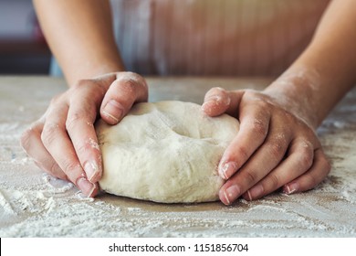 Female hands are kneading dough