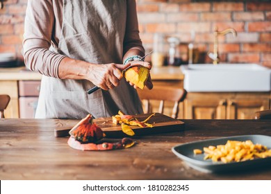 Female hands with knife chopping pumpkin on cutting board. Preparing autumn vegetables.  - Powered by Shutterstock