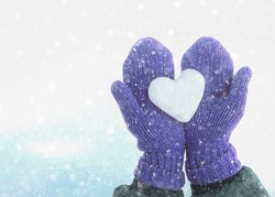 Female hands in knitted mittens with heart of snow in winter day. Love concept. Valentine day background., a Holiday Photo by Augusta16