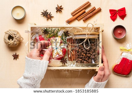 female hands laid care package, seasonal gift box with coffee, gingerbread and cinnamon Personalized eco friendly basket for family, friends for thankgiving, christmas, mothers, fathers day Flat lay 