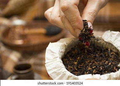 Female Hands Lifting Pipe Tobacco.