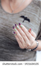 Female hands and long green   purple nails   bottle nail polish